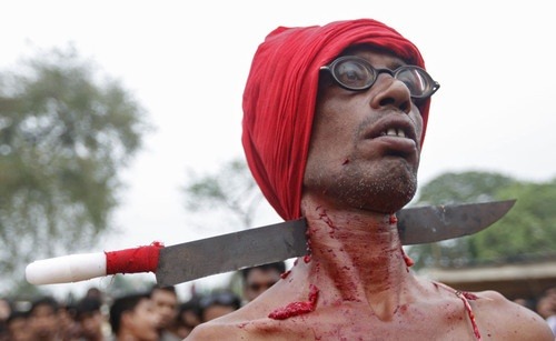 A Hindu devotee with his neck pierced with a knife attends the “Chadak” ritual