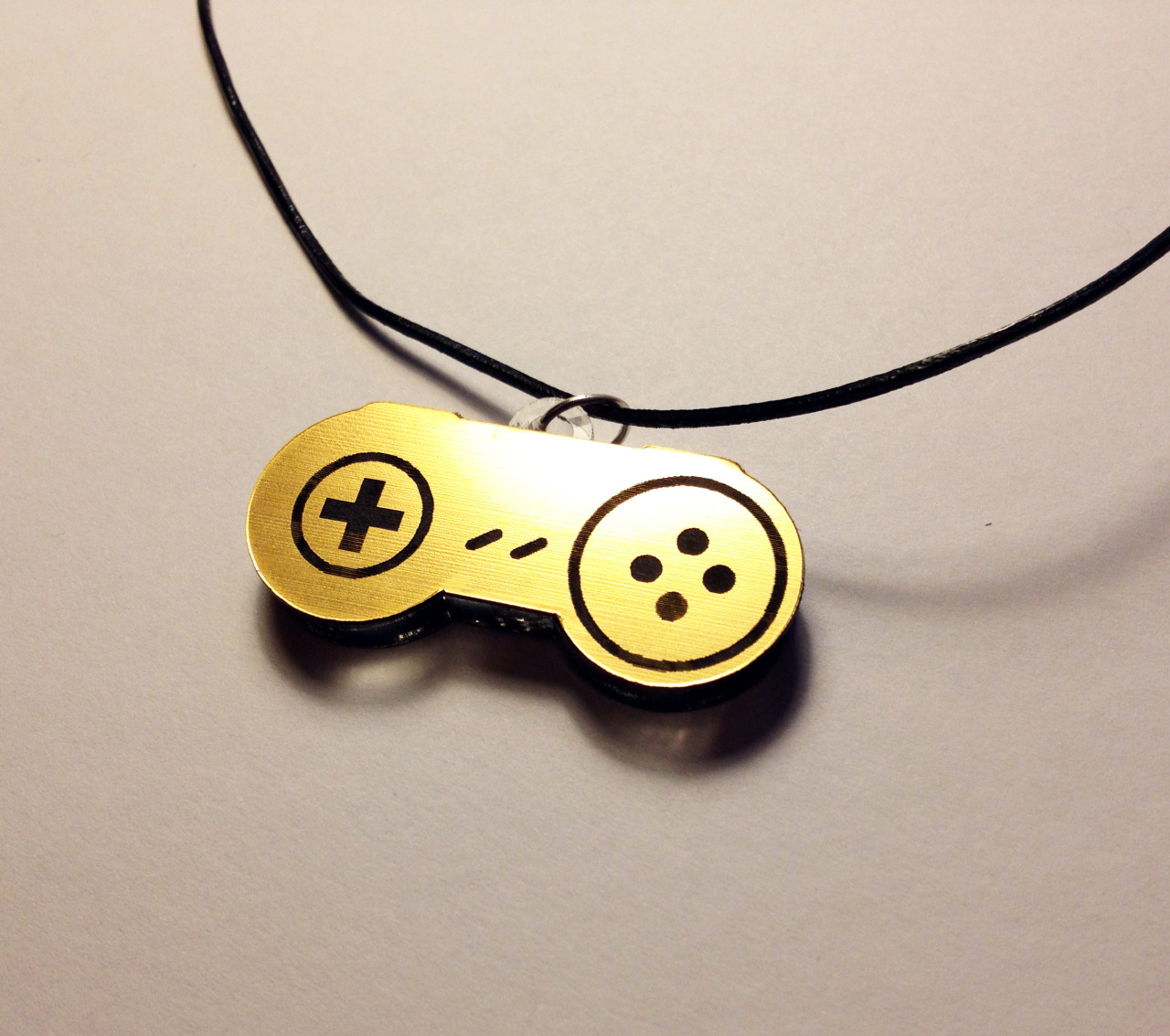 the-daily-robot:  New Laser-etched NES and SNES gamepad necklaces (in gold or silver!)