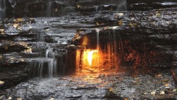 tea-and-skeletons:   Located behind a small waterfall in shale creek is a what seems to be a mysterious flame behind the water, known as the Eternal Flame Falls.  Behind this waterfall is a small crack in the surface that has allowed for a small amount