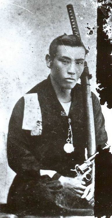 A Samurai posing with his katana and revolver, 19th century.
