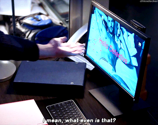 A gif of Chloe Decker gesturing to a computer screen. There’s a shirtless photo of Lucifer Morningstar with the words “Hello Detective” as the screensaver. Chloe says “I mean, what even is that?”