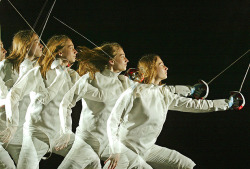 modernfencing:  [ID: a multiple exposure of a lunging sabre fencer with her mask off.]  Élora Pattaro in 2003! 