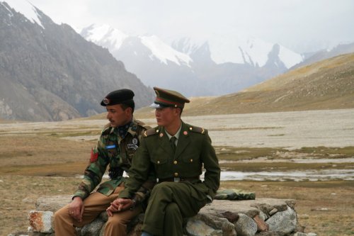 cancelledprogramming-deactivate:A Pakistani and Chinese soldier holding hands at the border.