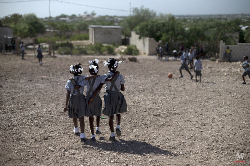 Schoolgirls walk through the rocky yard of Bethesda Evangelical School during a break in class, in C