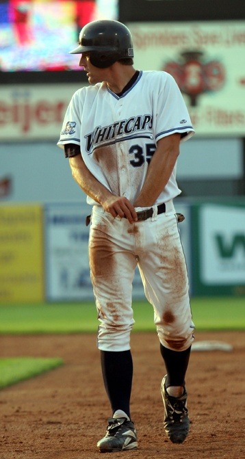 Baseball player, playing with his balls on field.
