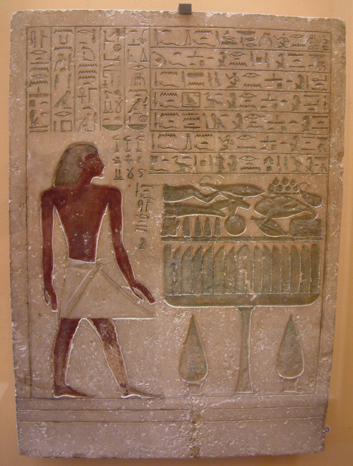 Ancient Egyptian painted stele representing a steward named Senousret standing before a table of off