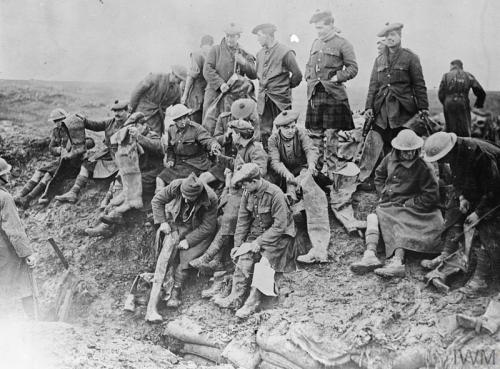 Soldiers of the Gordon Highlanders putting on rubber thigh boots, Bazentin-le-Petit, November 1916.