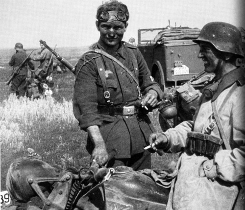 Two German dispatch riders on the Eastern Front share cigarettes, and probably their desire for a sh