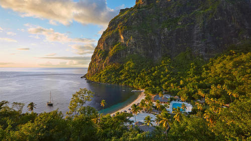 Wedged between the primeval Pitons, St. Lucia’s emerald, UNESCO-listed twin peaks, Sugar Beach envel