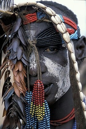 constantarrival:Karo man wears wearing face paint, beads and cowry shells near Omo River in southern