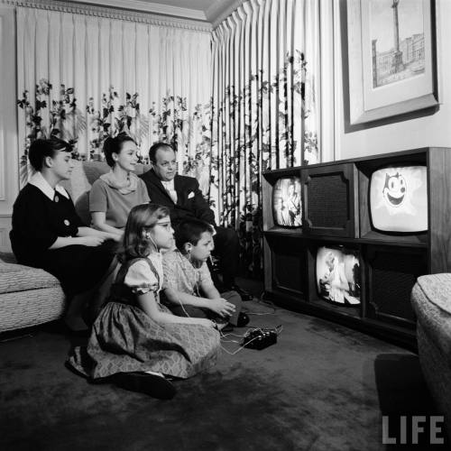 Family watching console with three separate televisions(Francis Miller. 1961)