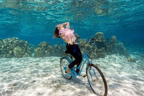 Sexy girl riding her bike underwater.