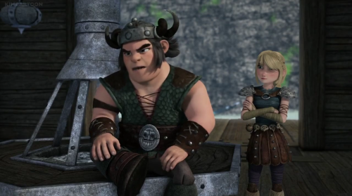 a screencap of Snotlout sitting on Hiccup's work bench, with Astrid standing behind him.