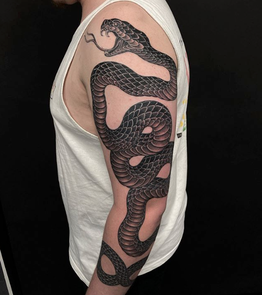 Sleeve tattoo with a snake, gun, weed symbol and a medallion tattoo idea |  TattoosAI