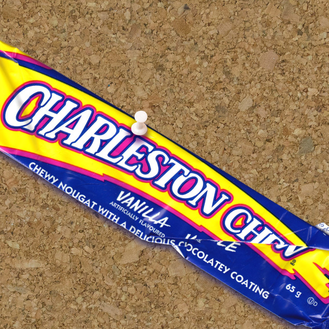 A Charleston Chew wrapper pinned to a cork board. 