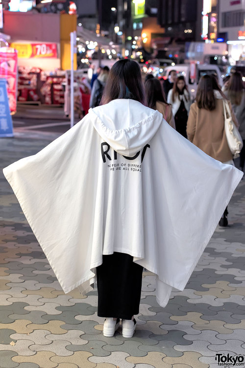 Elleanor on the street in Harajuku wearing a hooded &ldquo;RIOT&rdquo; cape from the Finland brand H