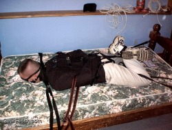 leatherbdsm:STRAIGHT JACKET &amp; HOGTIED  Pull the arms of the straight jacket behind for a secure restraint.  This guy is not moving anywhere.  