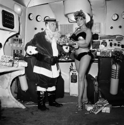 Bobbi Shaw plays Santa’s helper to Buster Keaton’s Claus, exchanging gifts on the set of “Beach Blanket Bingo” in 1964. (AP Photo)