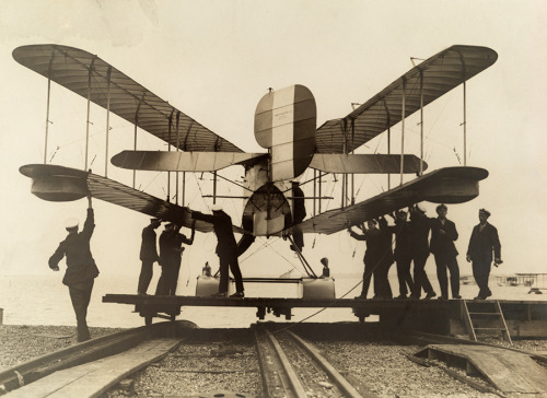 Men inspect a British airplane with folding wings, 1918.No Credit Given