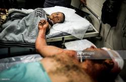 momo33me:  Palestinian injured father Yahya Hassan ® holds his son Ahmed Hassan’s hand as they wait to receive treatment at Al-Shifa Hospital in Gaza City, Gaza on October 11, 2015 after Israeli Terrorists‬ carried out an airstrike on a house 