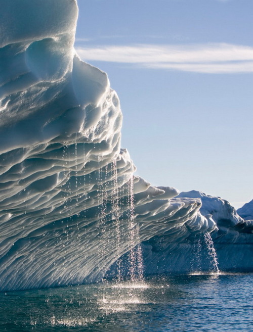 Melting water streams from iceberg in Disko Bay, Greenland (by faceofclimate).