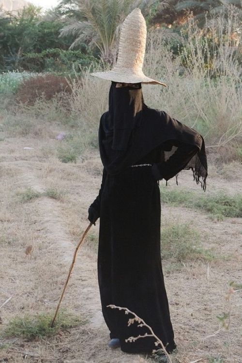 Women in Hadramaut, Yemen wear an all black abaya and conical straw sunhat called a madhalla when wo