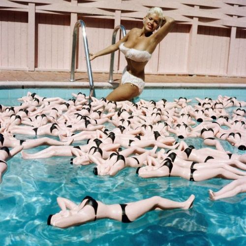 LIFE legend Jayne Mansfield posing in a bikini at the edge of a swimming pool filled with bottles sh