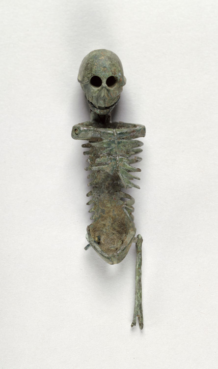 ancientart:Miniature Skeleton, Roman, 1st century, bronze, from Asia Minor.In Petronius’ satirical novel, the Satyricon, written in the 60s A.D., Trimalchio, the crass, nouveau riche host of a dinner party, has a small silver skeleton brought out between