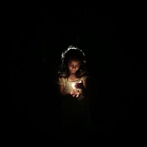 tanyushenka:A Palestinian girl holds a candle in front of her home during a power cut at the Jabaliy