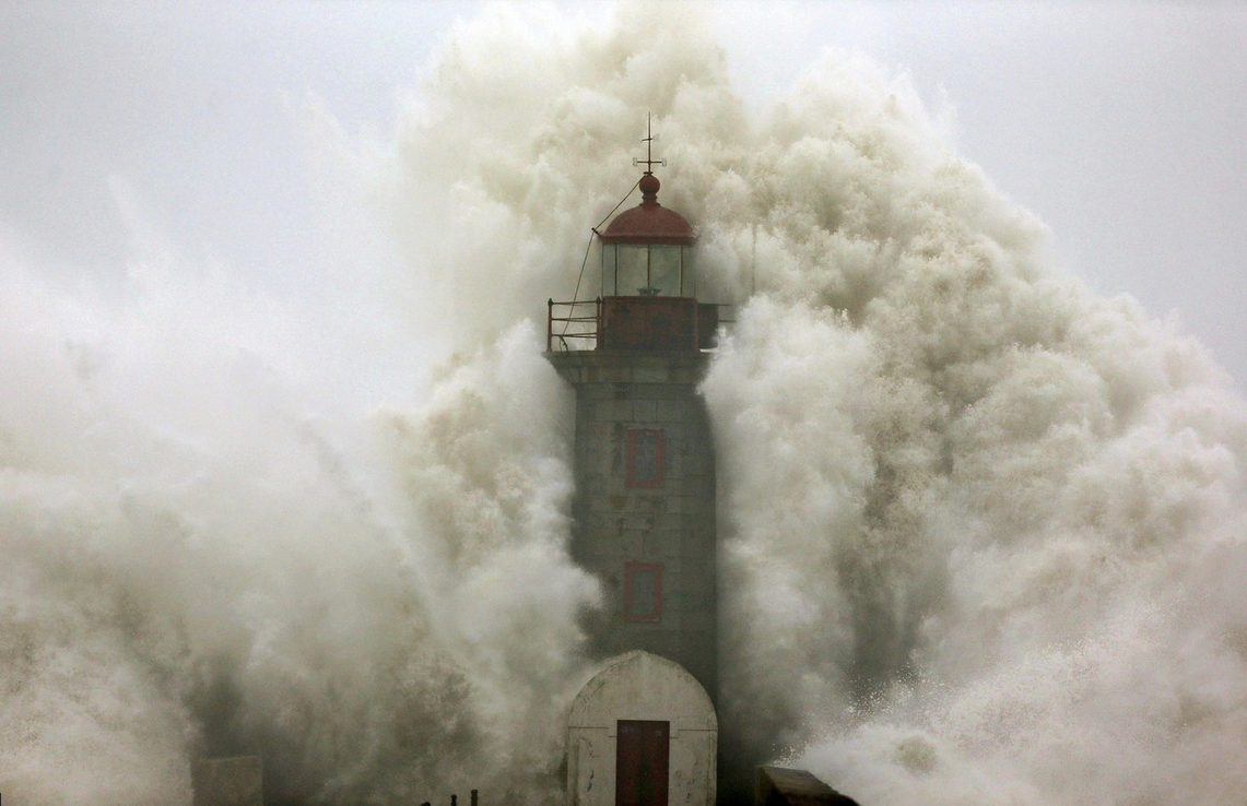 softwaring:  A wave crashes into a lighthouse in Porto, Portugal. The photographer