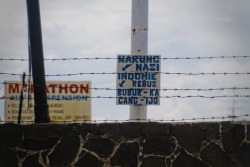 A small sign for a small food stall behind barbed wire. Bandung, Indonesia