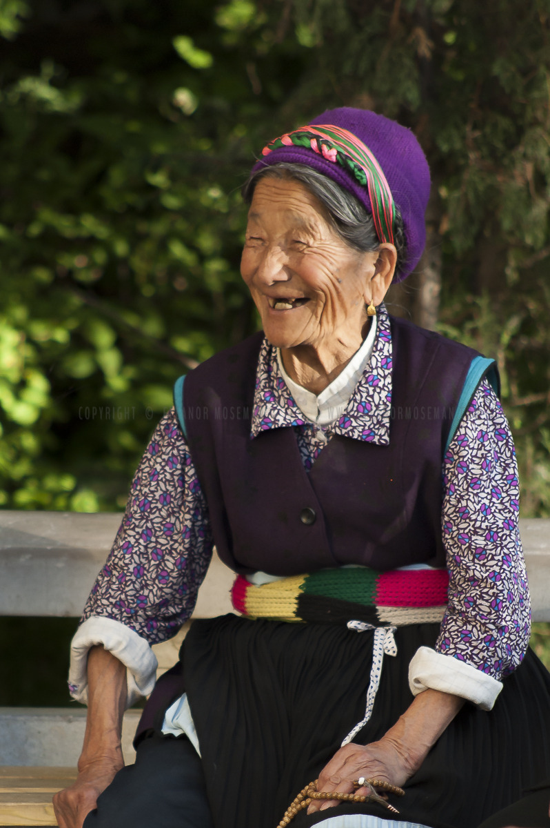 Buddhist woman taking a break from spinning the largest prayer wheel in Asia. Zhongdian (Shangri La) China, 2011