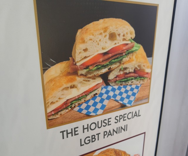 Picture from a menu; under a photo of three panini sandwiches, the text "The house special LGBT panini" is written