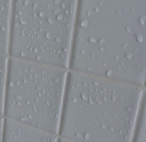 supine-aesthetic: image description: white tile covered in water droplets