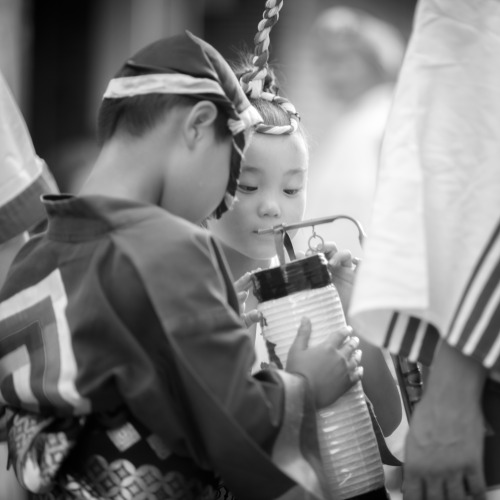  Young dancers examine a handheld lantern the adult dancers use in their performance. 