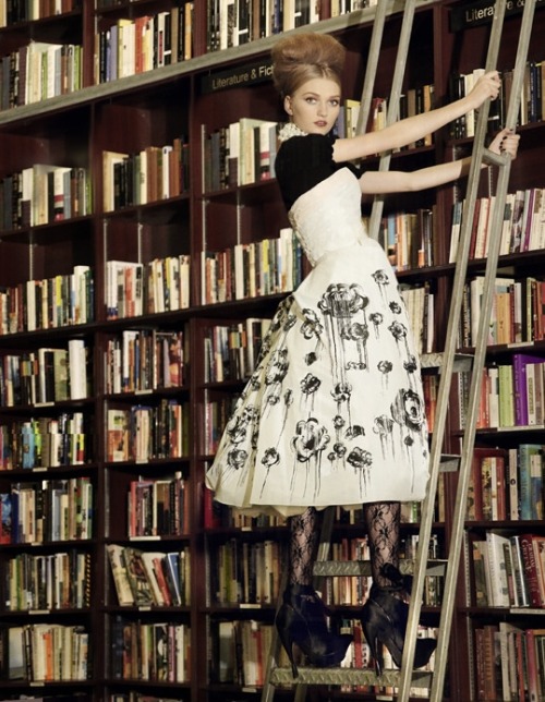 Model on library ladder looking for books. Photographed by Olivia Graham. The Gloss, 2013.Olivia Gra