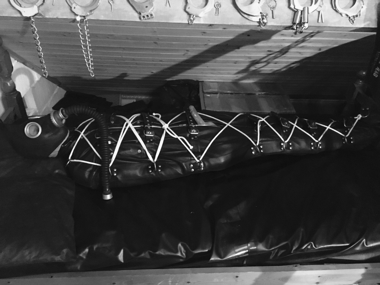 jamesbondagesx:  Gimp in full rubber, rubber hood, leather gimp hood, leather sleepsack