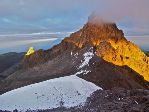 Mount KenyaThe peak peering out of the clouds and illuminated by the morning sun in this photo is Mo