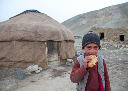  Wakhi nomad boy eating bread in front of his yurt, Big pamir, Wakhan, Badakhshan, Afghanistan. Take