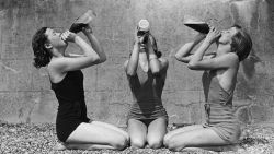  Circa 1937: Three women quenching their thirst on the beach at Shoeburyness in southeast Essex, England. 