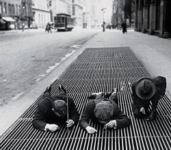 historicaltimes:  3 boys fish for change in the street grates during the depression. N.Y.C. 1930 