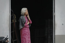 A gray-haired woman looks on worriedly. Bandung, Indonesia