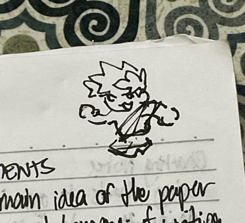 a zoomed-in picture of a traditional doodle of zagreus. he has a cat-shaped mouth. he is drawn crudely next to cropped handwritten text that says “main idea of the paper”