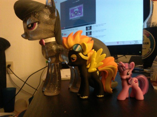 Size comparison shot of a full vinyl figure, the new blind… box? pony, and a regular blind bag pony.