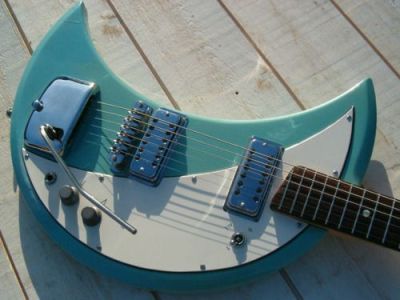 thepit:bleachedvi0let:Crucianelli Spazial 1965 Crecent Moon guitar 🌙[ID:4 pictures of an electric guitar taken from various angles. Its body is in the shape of a crescent. It’s light blue with a white pickguard. It has a vibrator arm/End ID]