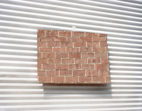 thejogging:Taping Bricks To A Closed Garage Door, 2014documentation of performance∆