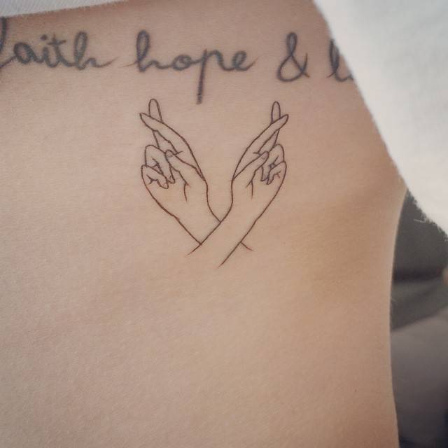 Crossed fingers tattoo on the ribs. Tattoo artist: Doy