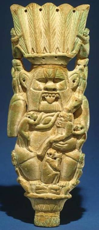 faience plaque of the God Bes sitting on a lotus flower, and surrounded by monkeys; in His left arm 