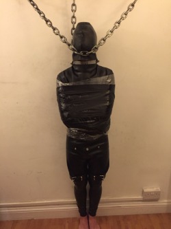 pigfun:  I’m in that rubber straitjacket I was talking about in my last post, and I’m wrapped even tighter with cling film and duck tape. Also hooded, and chained to the wall with a chain holding my head up. 