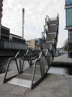 madflamingo:  10 Cool Pedestrian Bridges Around The World Rolling Bridge, London The designer for the Rolling Bridge, Thomas Heatherwick created a remarkable piece of mechanical engineering. At first it looks like an ordinary steel footbridge, but …